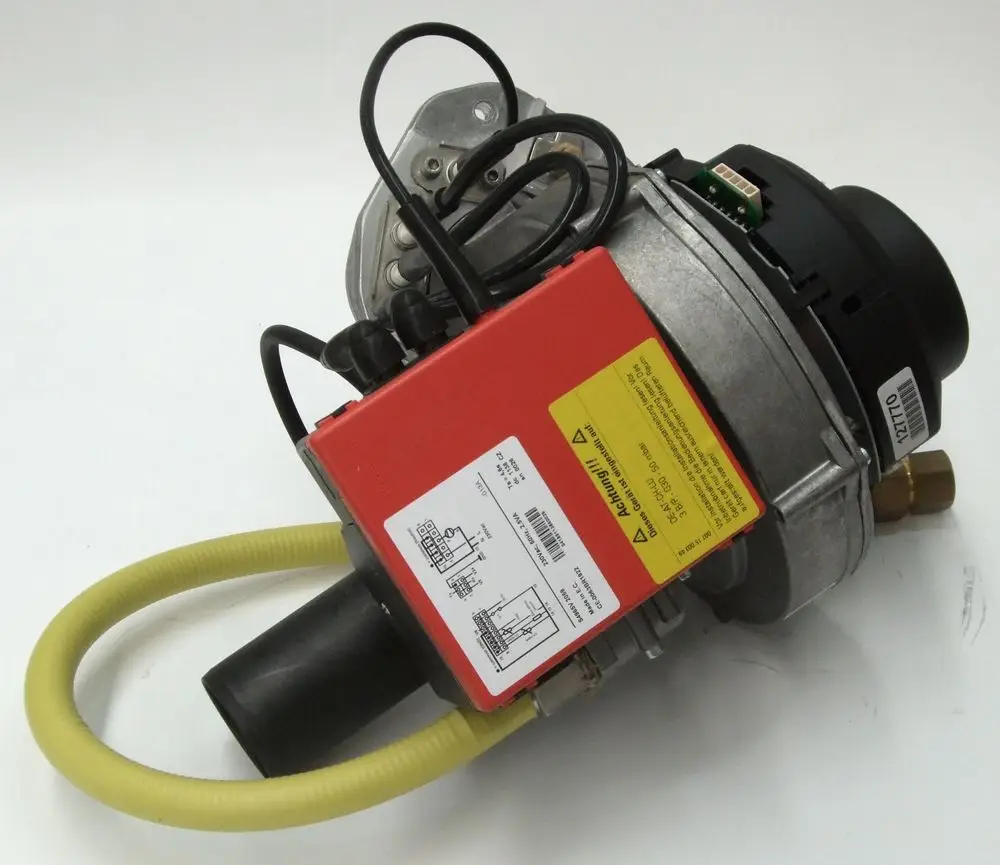 Brennermodul von Daikin mit rotem Gehäuse und mehreren Anschlüssen, verbunden mit einem flexiblen Schlauch. Die Montagehalterung ist deutlich sichtbar.